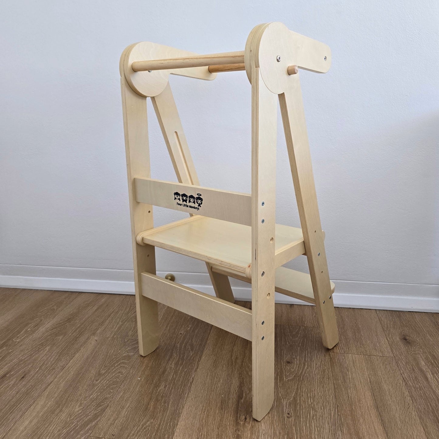 Angled rear view of Four Little Monkeys Natural Adjustable Foldable Learning Tower showing the brand logo.