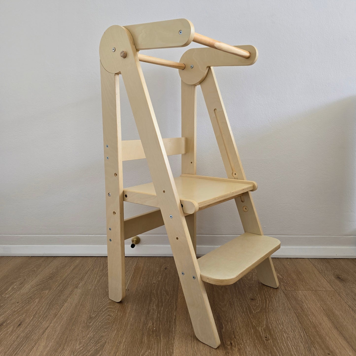 Front angled view of the Four Little Monkeys Natural Adjustable Foldable Learning Tower, highlighting its sleek design.