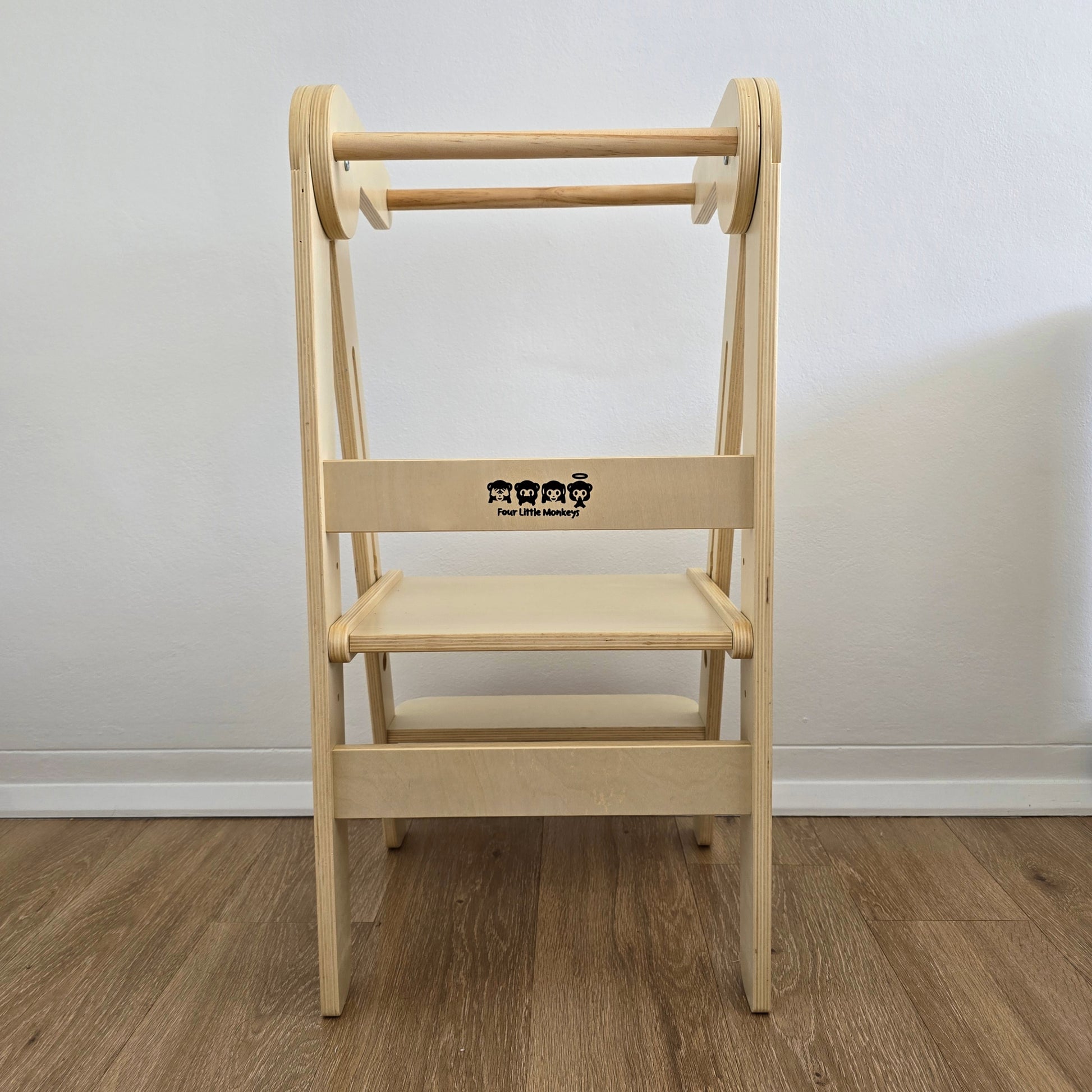 Direct rear view of Four Little Monkeys Natural Adjustable Foldable Learning Tower, featuring the clear display of the brands logo.