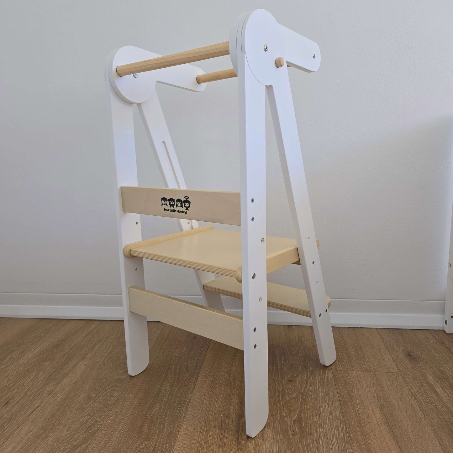 Angled rear view of Four Little Monkeys White Adjustable Foldable Learning Tower showing the brand logo.
