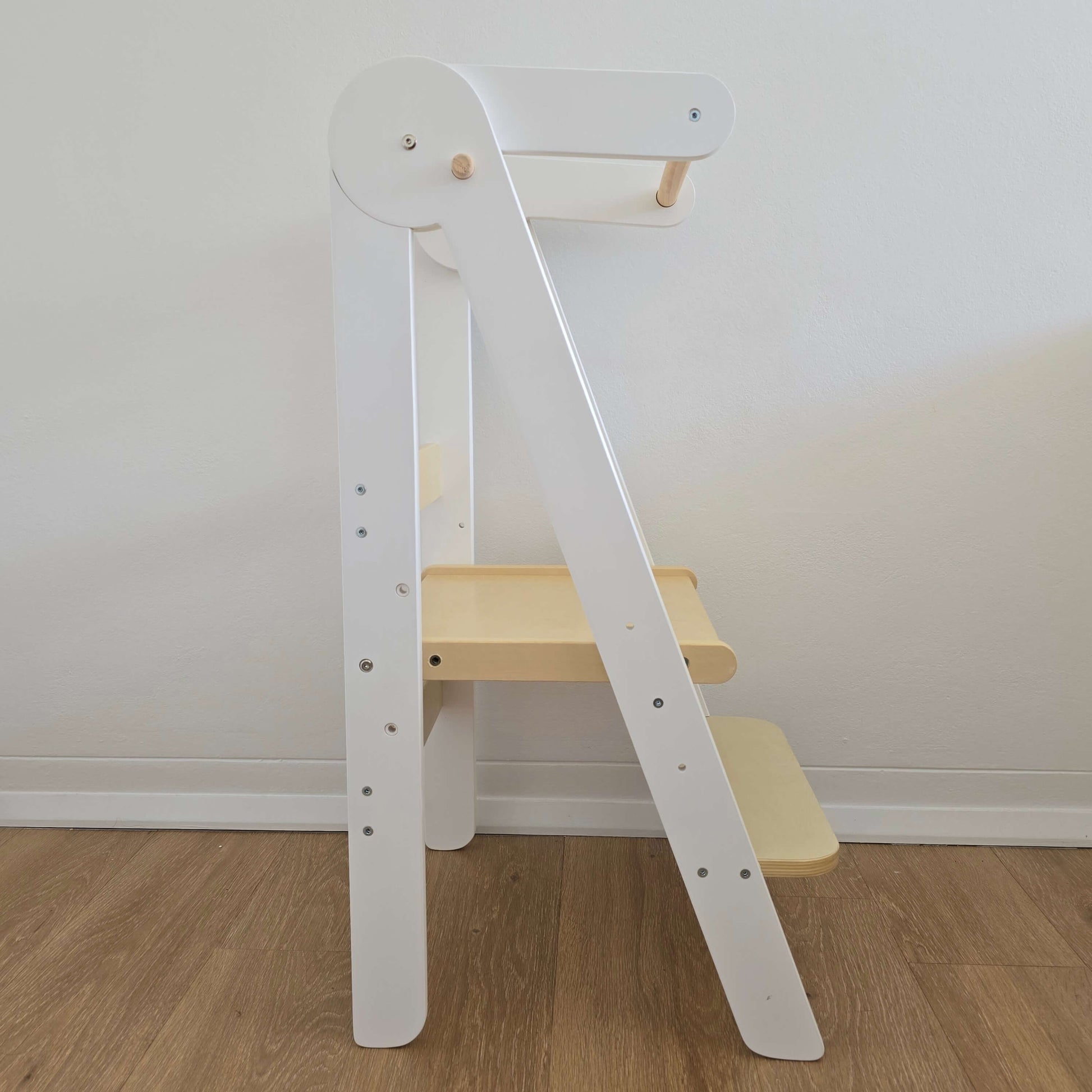 Side view of the Four Little Monkeys White Adjustable Foldable Learning Tower demonstrating its slim profile.