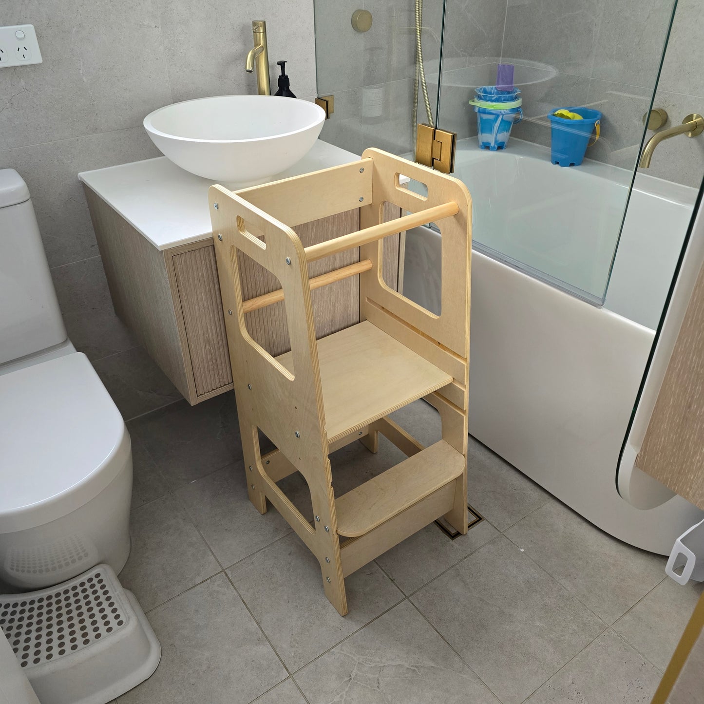 Natural Adjustable Learning Tower positioned at a bathroom sink, ready for use.