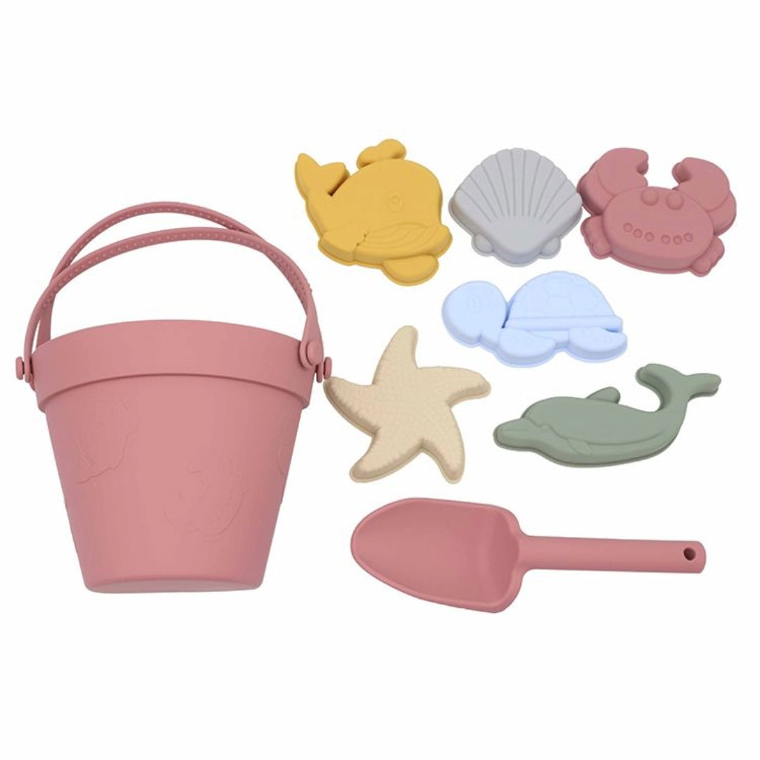 Complete Maroon Silicone Beach Set, including one bucket, one shovel, and five moulds laid out on a white background, highlighting the unbreakable and dishwasher-safe features of the hypoallergenic, BPA-free silicone toys.