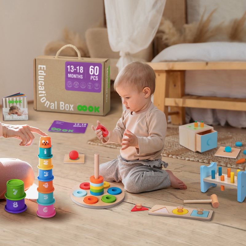 Image showing a delighted toddler aged 13 to 18 months, exploring and playing with the items from the Monkey Learn and Play Kit. The child appears deeply engaged with a colorful wooden stacker, illustrating a fun learning experience.
